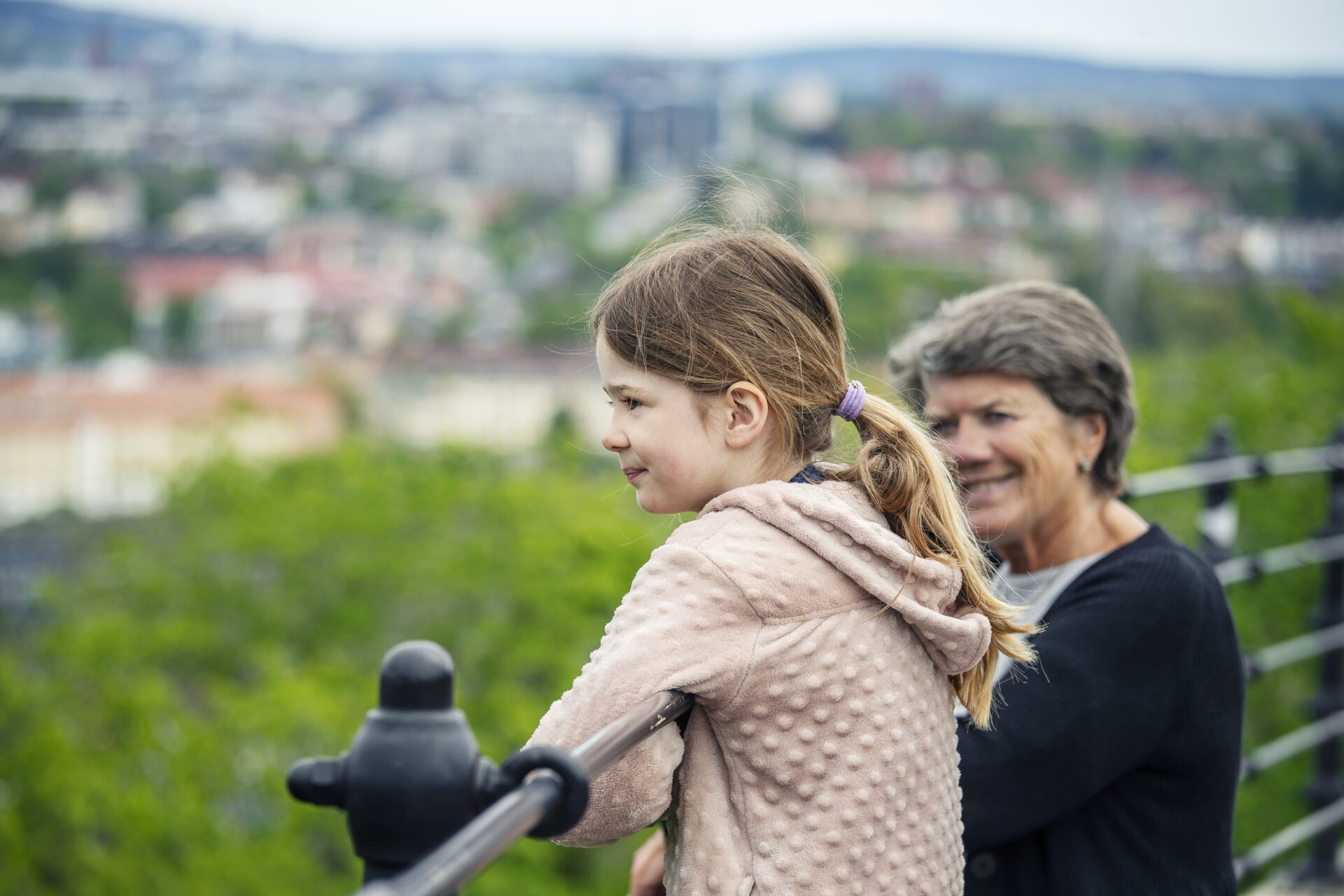 Kvinne og barn står på en høyde og ser ut over Oslo.
