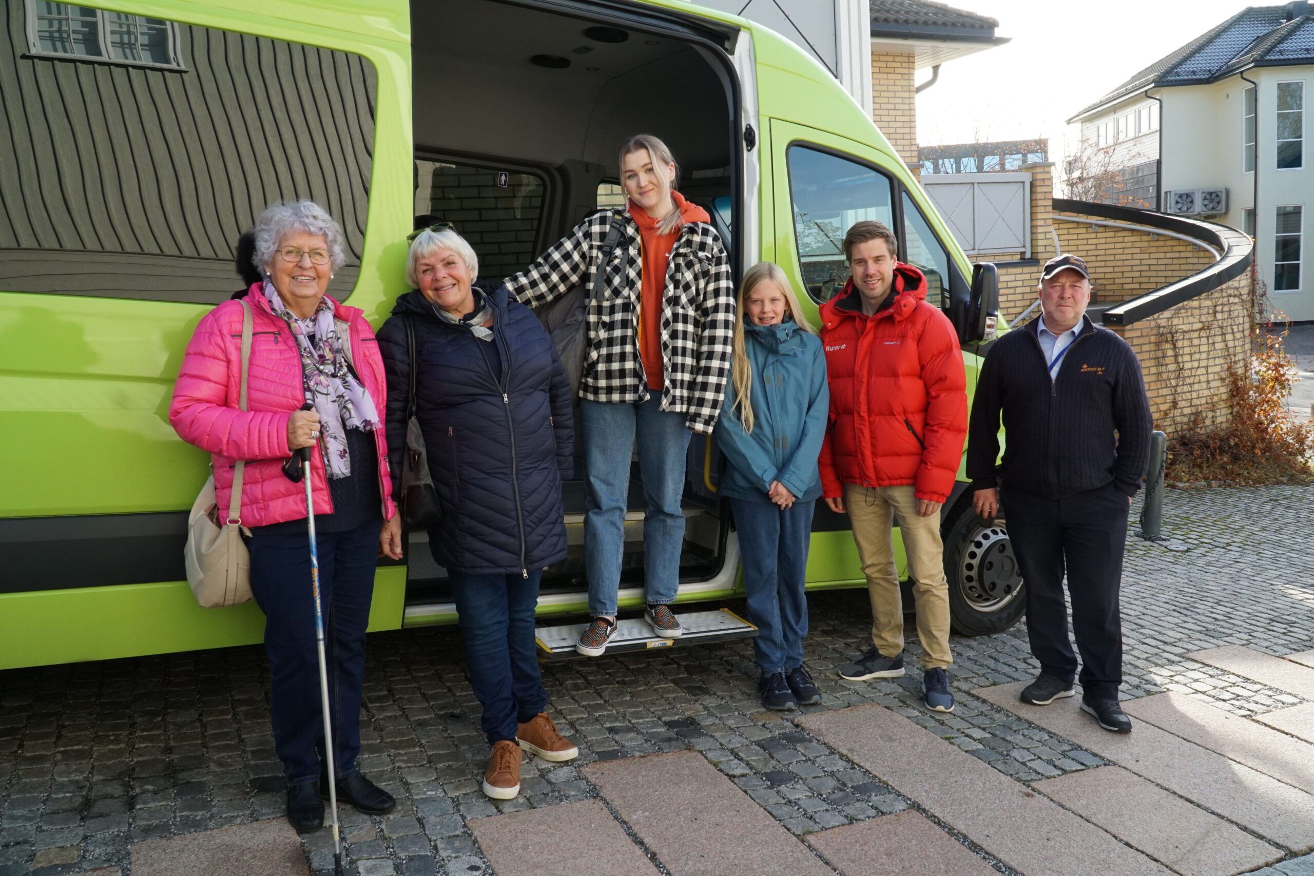 Unge og eldre modeller foran en grønn bil for bestillingstransport.