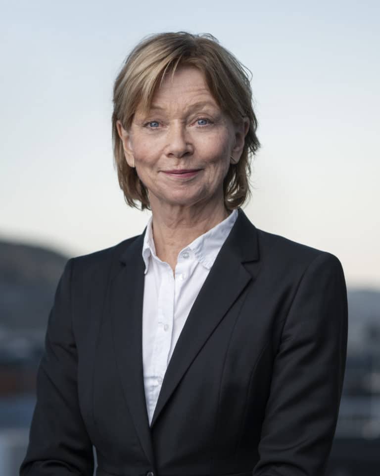 Portrettbilde av Kristin Bjella med landskap i bakgrunnen.