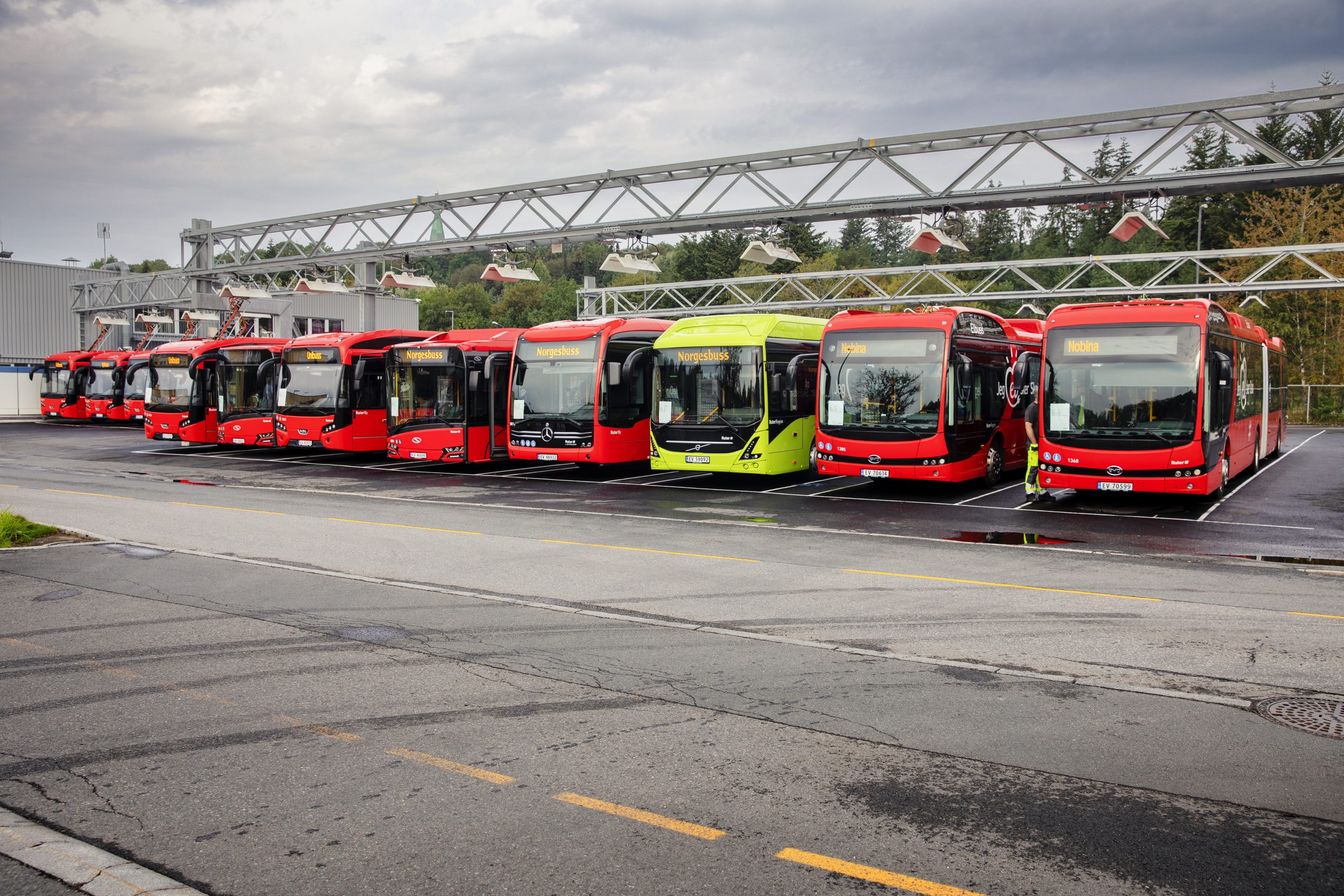 Ruter elbusser står parkert på rekke og rad mens de lader.