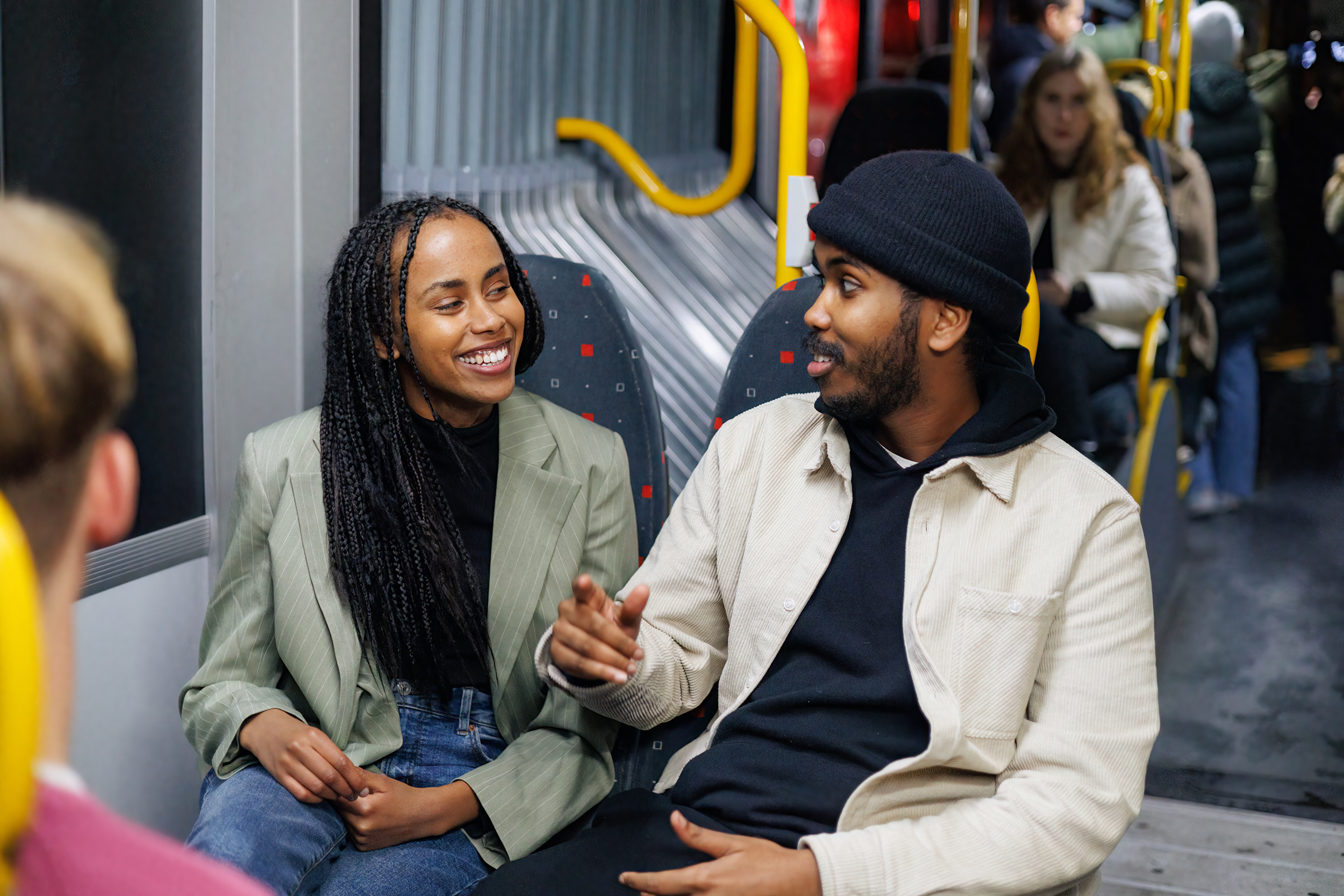 To passasjerer i en hyggelig samtale sittende på en buss.