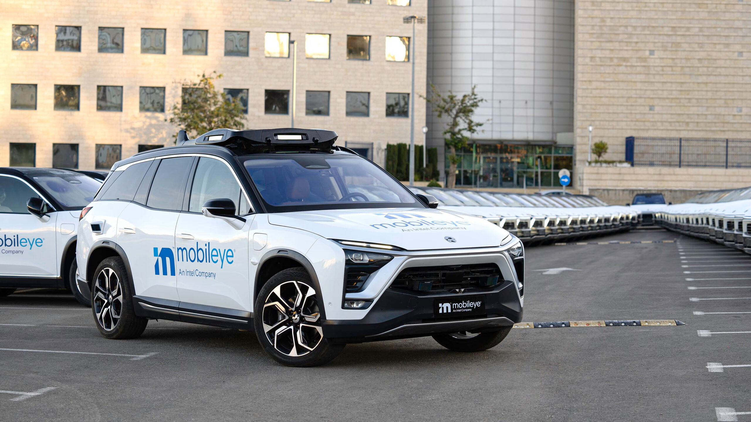 A white car with a blue Mobileye logo on it.