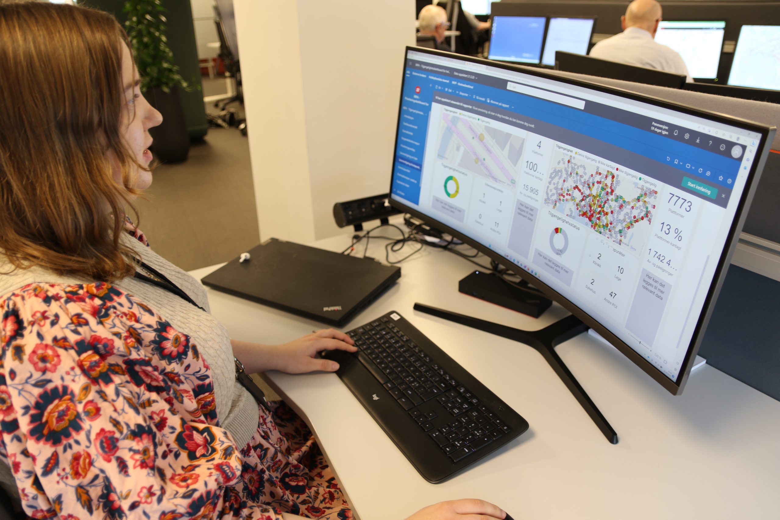 Woman looks at a computer screen showing a new analysis tool for bus stop data.