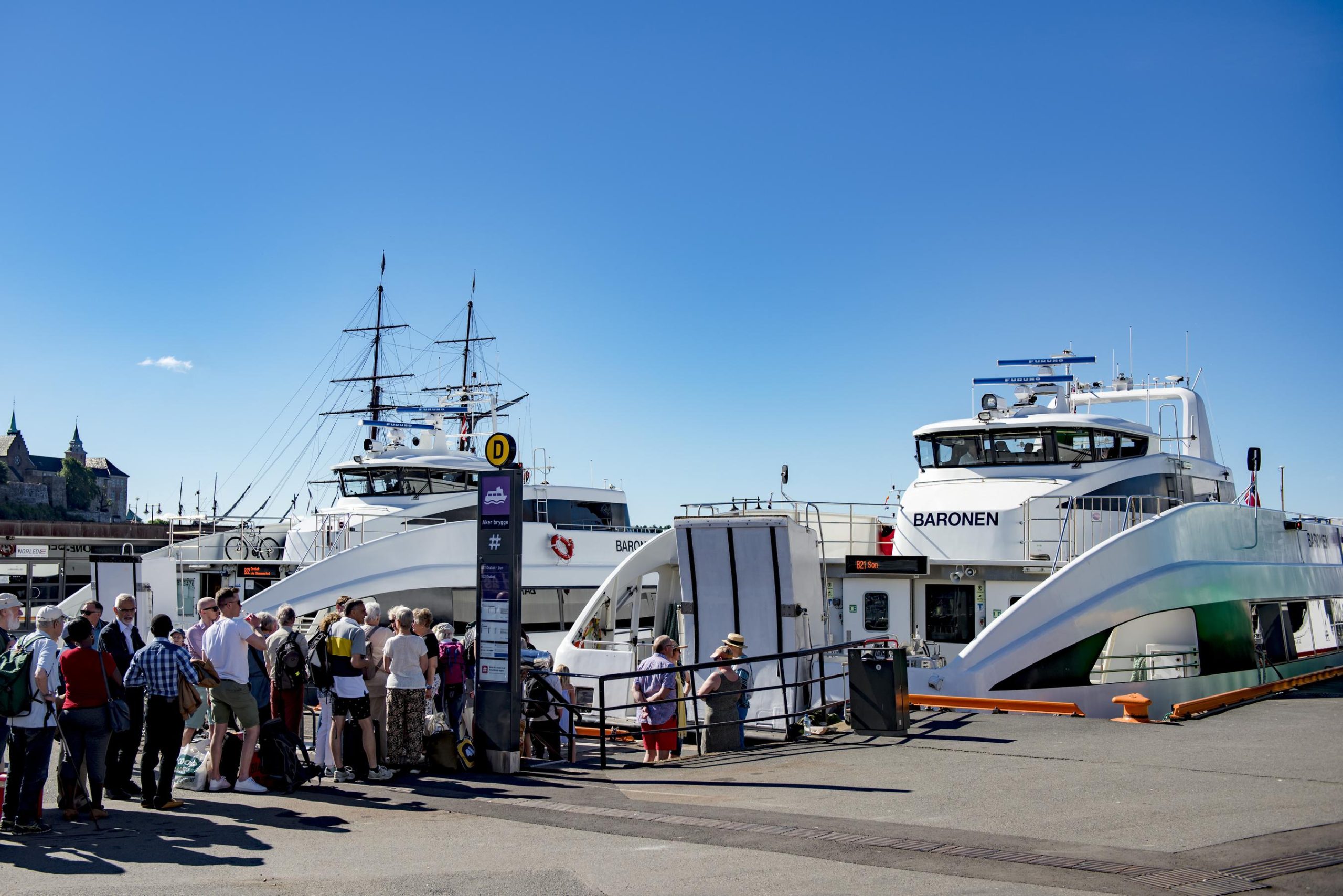 People queue to board a Ruter island ferry on a summer day.