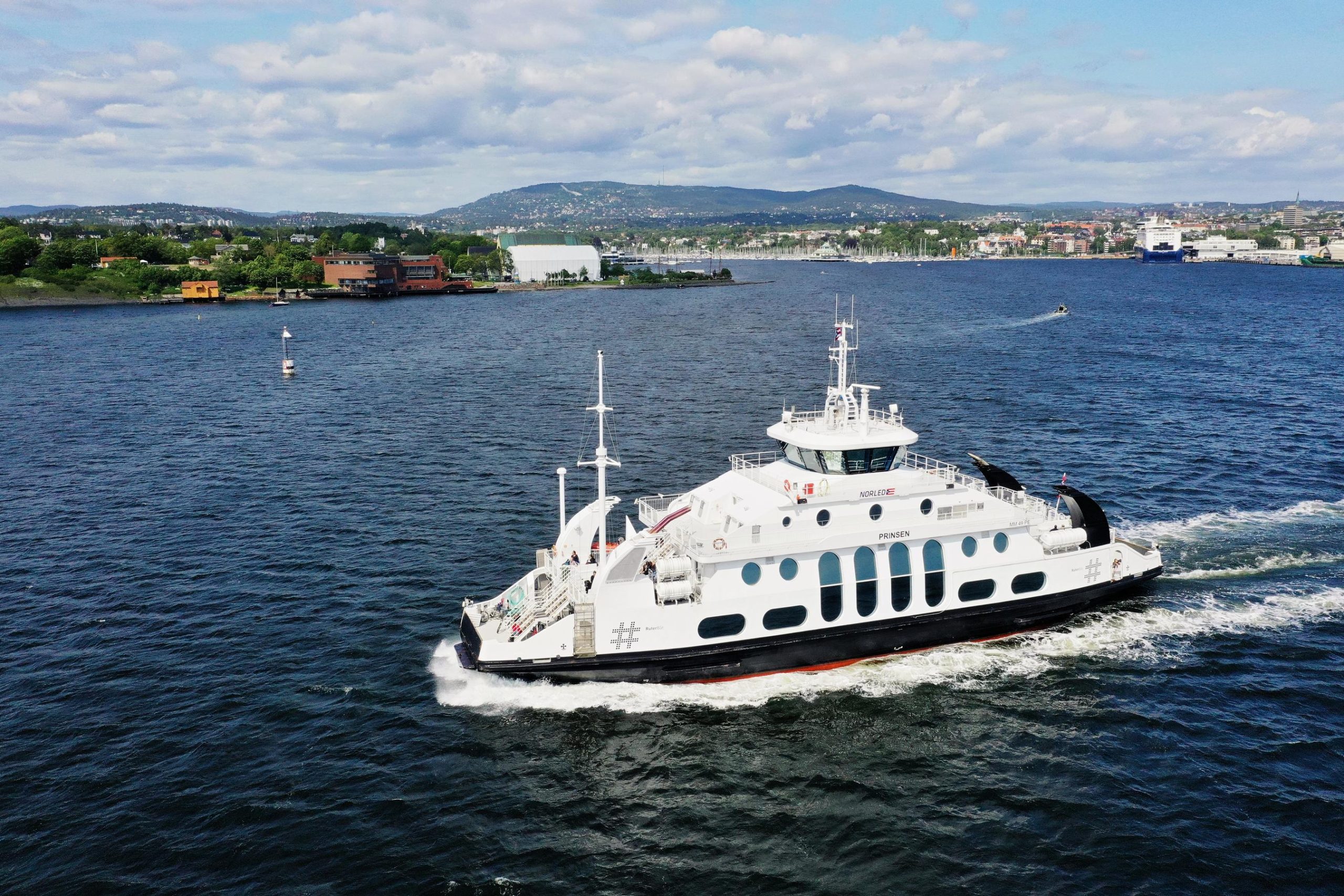 Island ferry on the sea with land in the background.